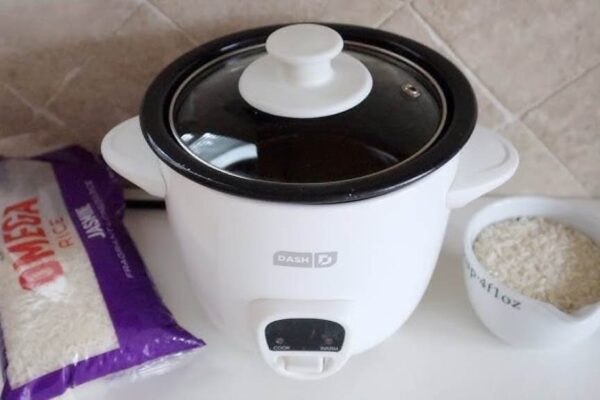 Compact Dash Mini Rice Cooker on a dorm desk with steaming rice