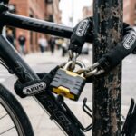 Heavy-duty U-lock securing a bicycle to a metal city rack.